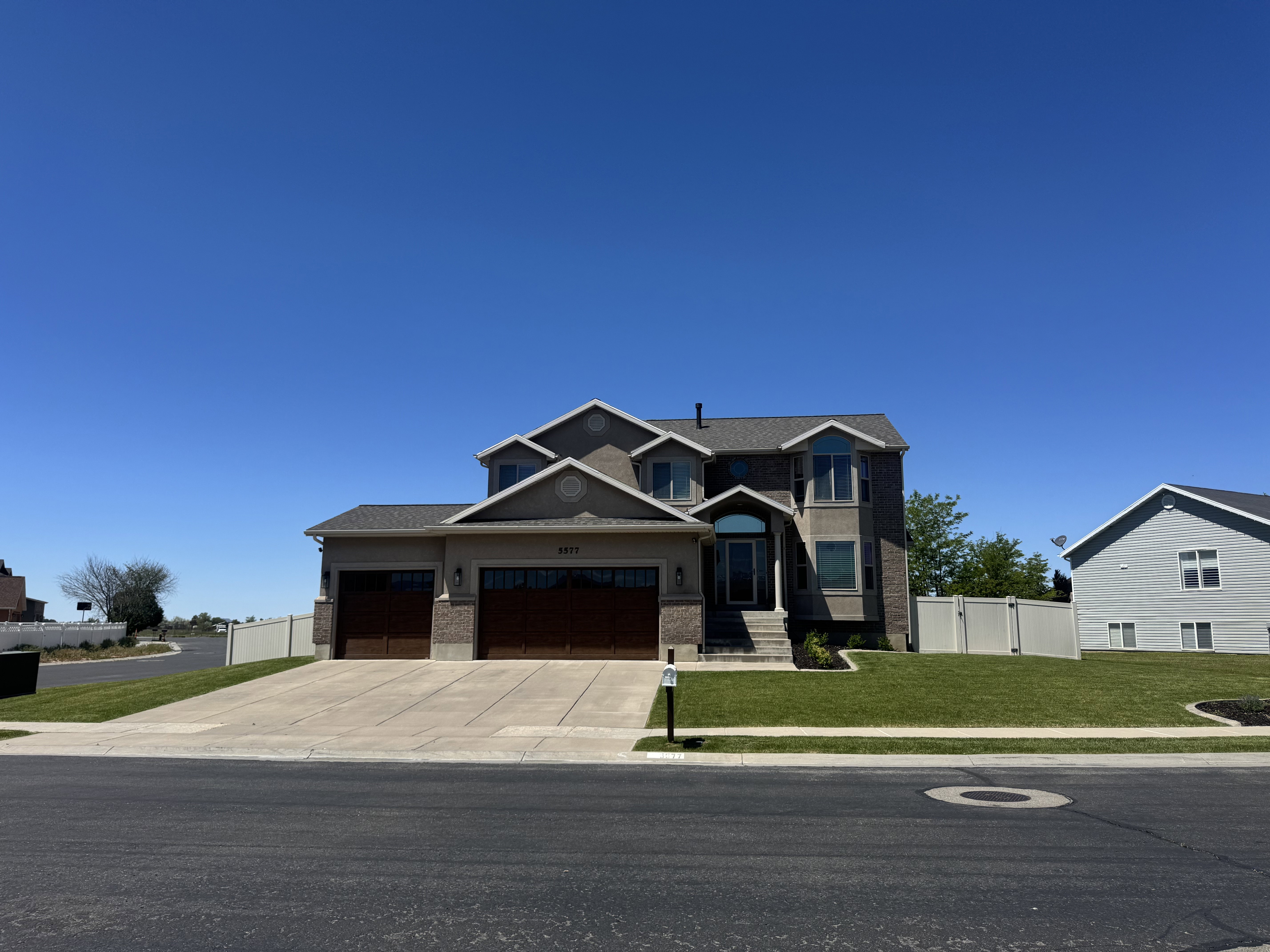 Two-story residence featuring a brick and stucco exterior, prominent bay windows, and a covered entry