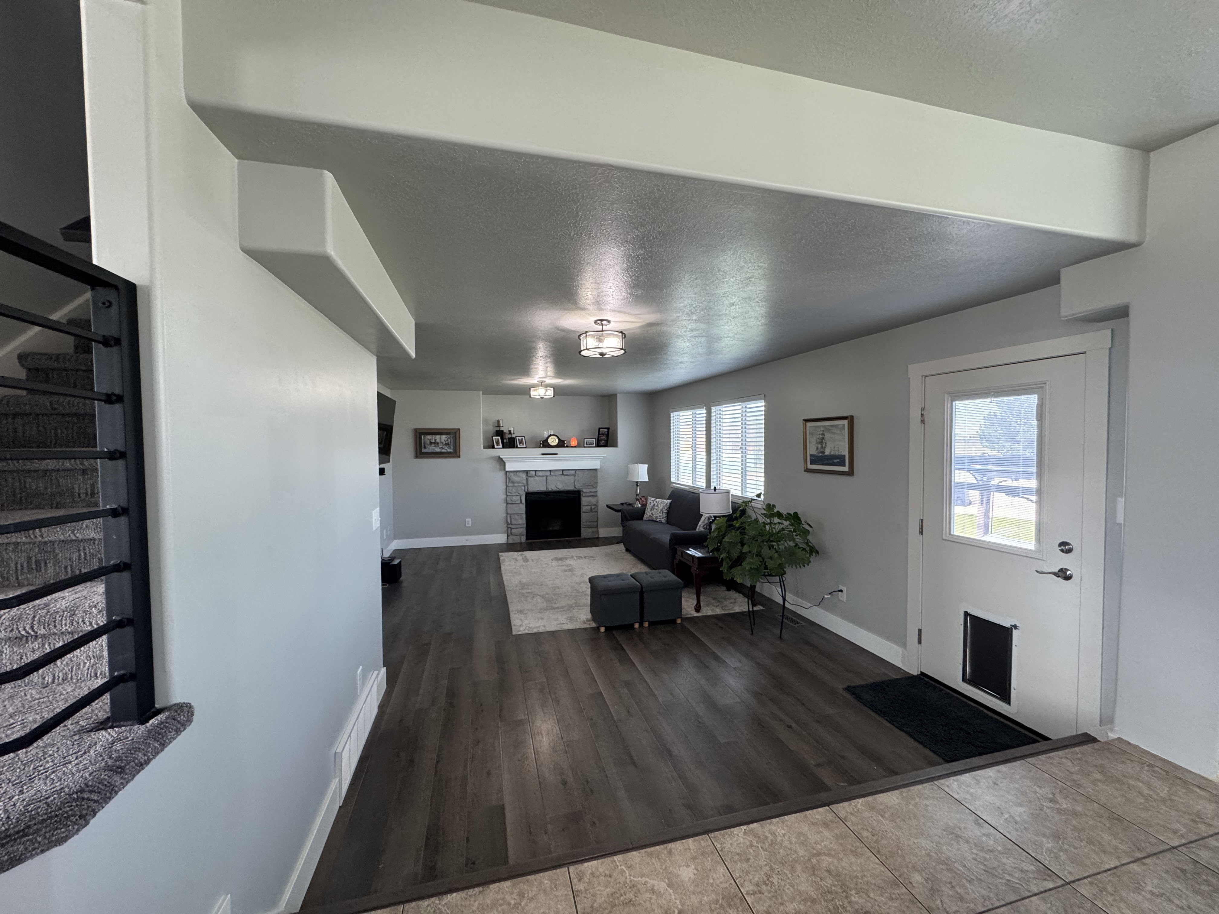 Living area featuring wood-finish flooring, recessed lighting, and a stone-clad fireplace