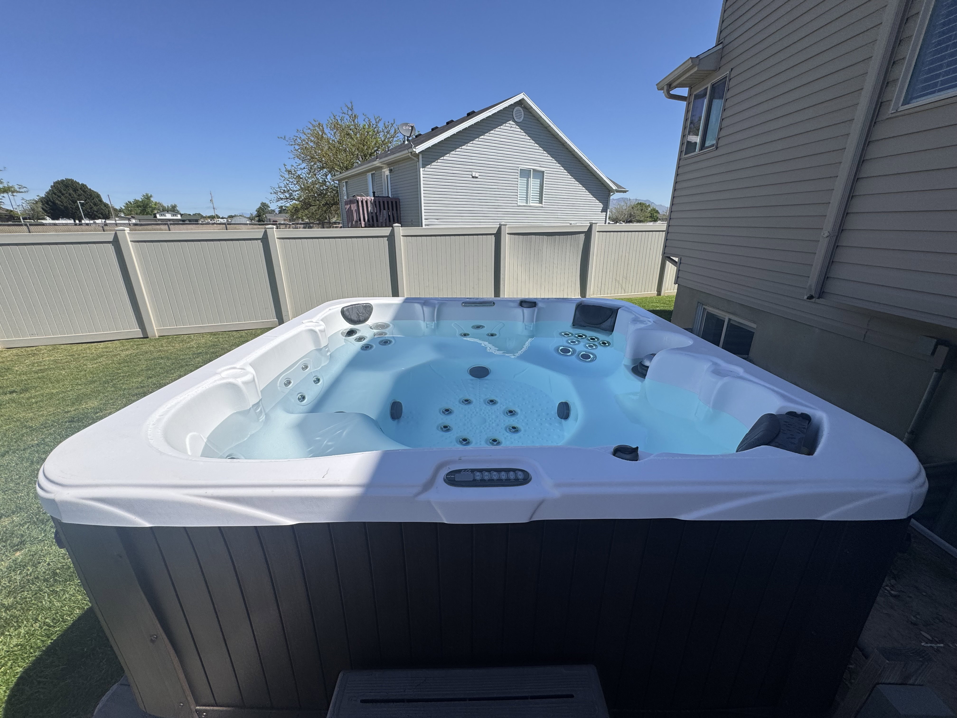 Contemporary hot tub with integrated lighting, set on a paver patio