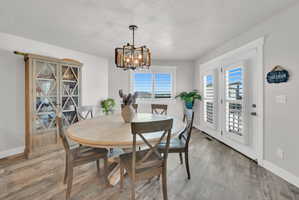 Dining area featuring wood-finish flooring and a contemporary chandelier