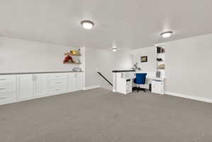 Built-in cabinetry with white shaker-style doors and drawers, dark countertops, and open shelving