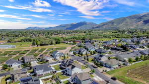 Established residential area with varied home styles, mountain backdrop, and agricultural land