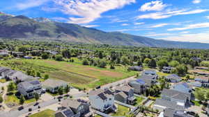 Residential neighborhood with a backdrop of snow-capped mountains and expansive green landscapes