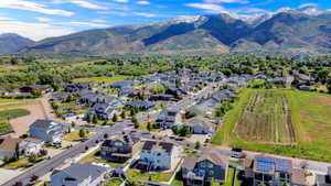 Aerial perspective showcasing a residential neighborhood with a backdrop of snow-capped mountains