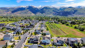 Residential community featuring a variety of single-family homes, mature trees, and a mountain backdrop