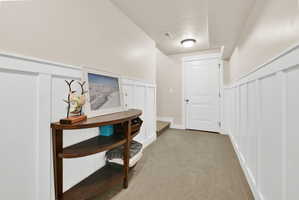 Hallway featuring board and batten wainscoting, light neutral wall paint, recessed lighting, a ceiling-mounted light fixture, and carpet flooring