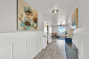 Hallway featuring wainscoting, wood-finish flooring, and recessed lighting
