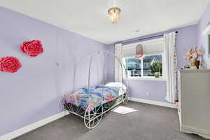 Room featuring a large window with white blinds and curtains, recessed ceiling vent, and a flush-mount crystal chandelier