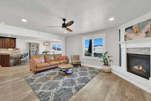 Open-concept living area featuring wood-finish flooring, recessed lighting, and a ceiling fan