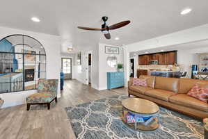 Open-concept living area featuring wood-finish flooring, recessed lighting, and a ceiling fan