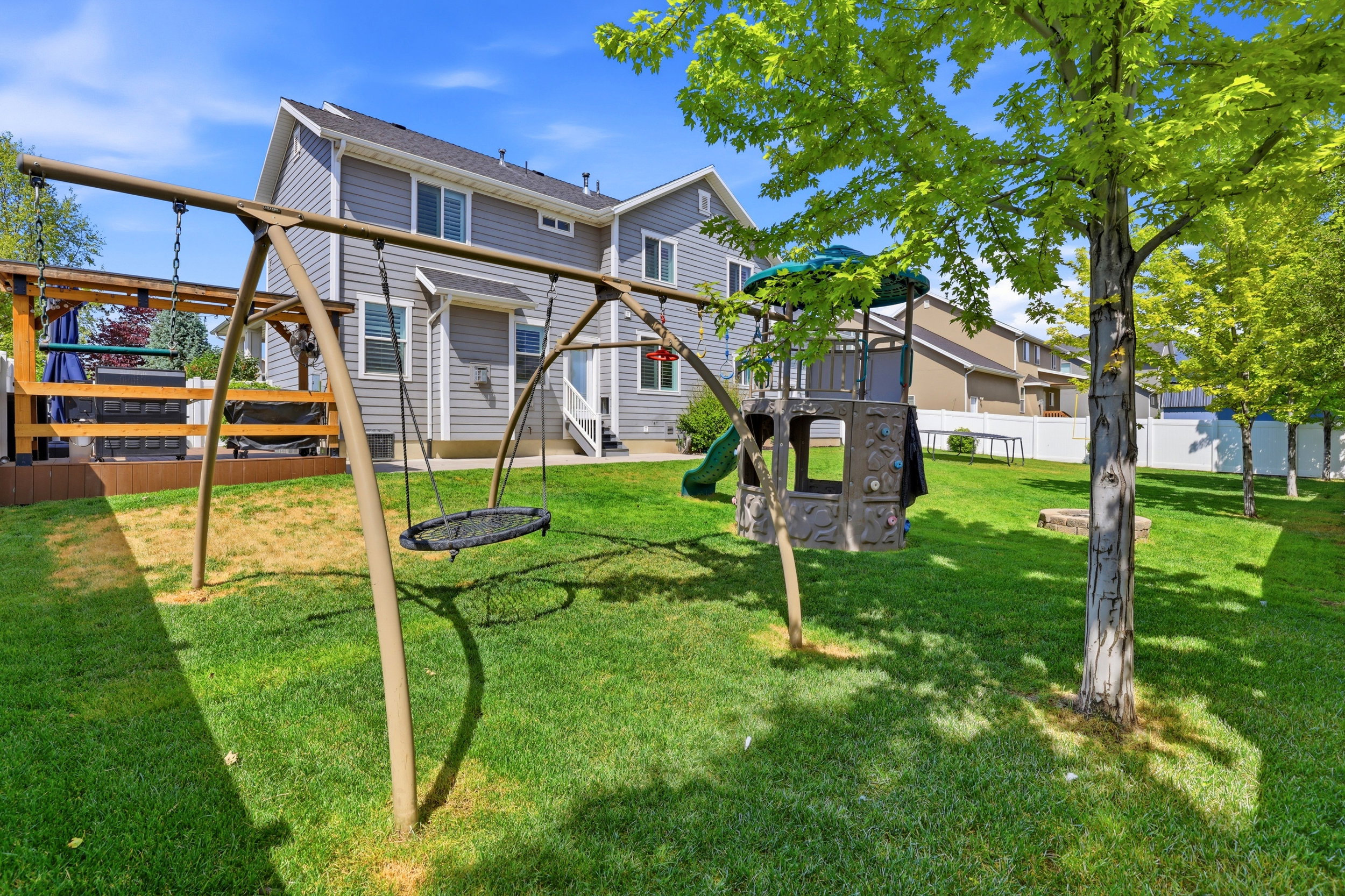 Expansive green lawn featuring mature trees