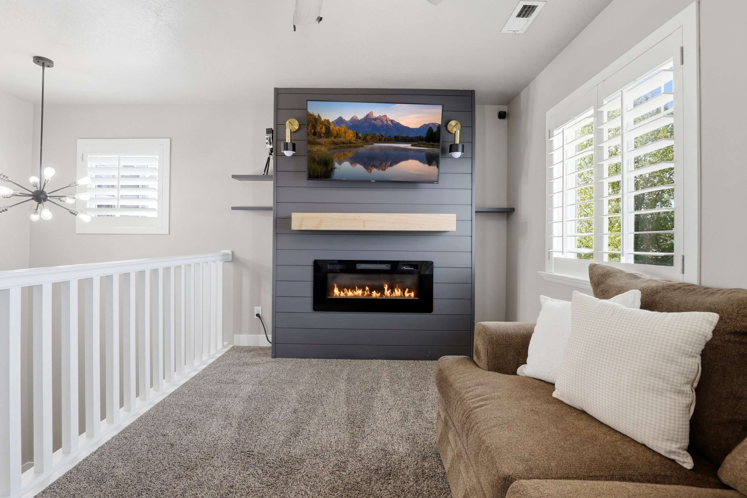 Contemporary living area featuring a built-in fireplace with a dark shiplap surround and a light wood mantel