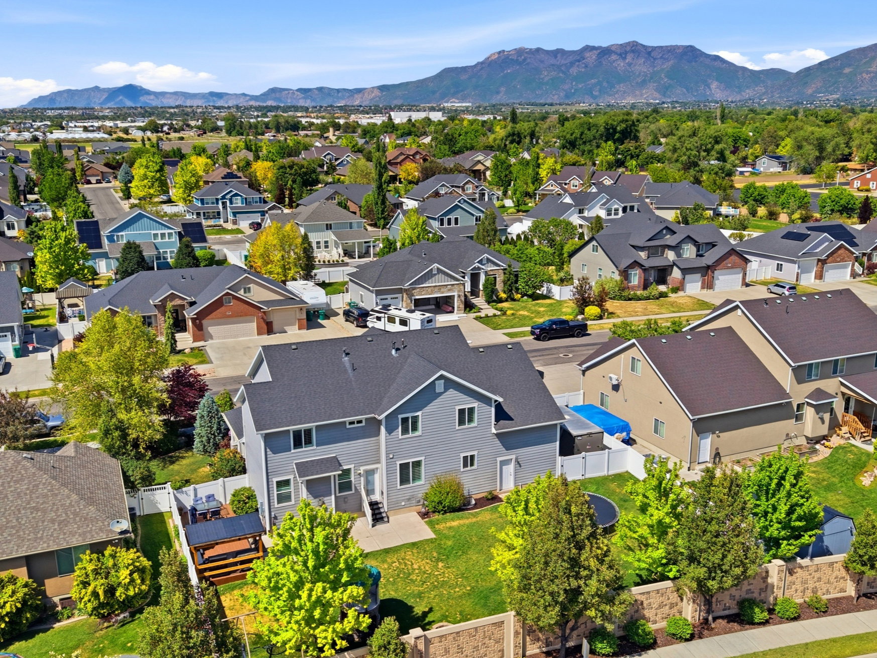 Residential neighborhood featuring mature trees and mountain backdrops