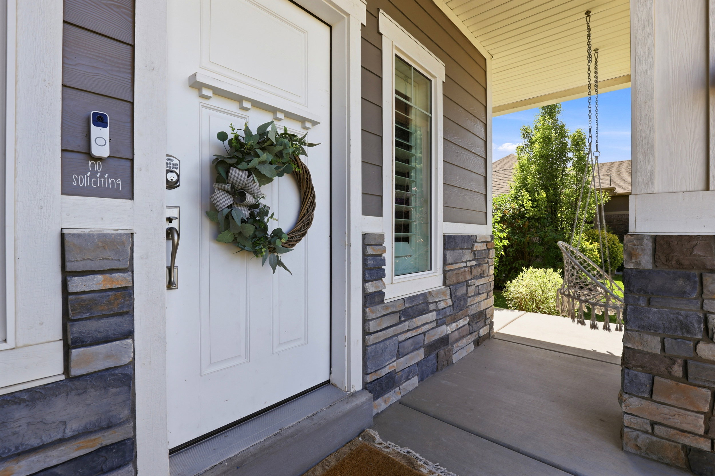 Inviting covered front porch with stone and siding exterior