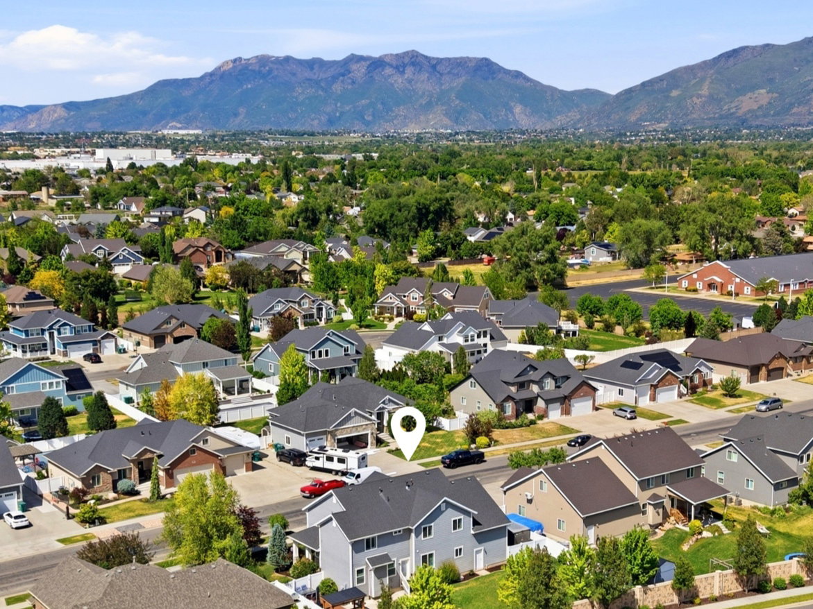 Residential community featuring varied home styles, mountain backdrop, and tree-lined streets