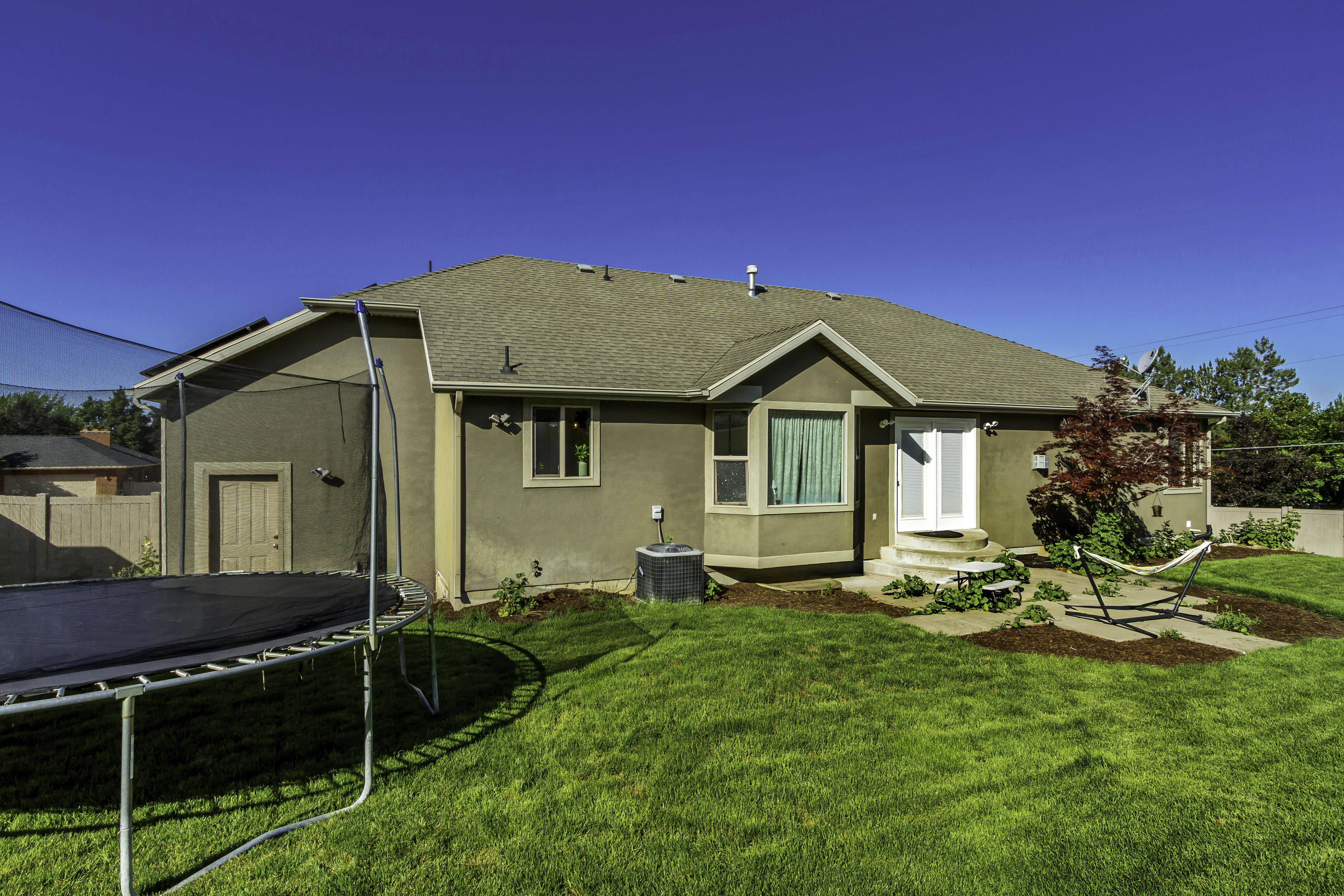 Expansive backyard with manicured lawn and mature landscaping