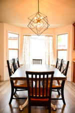 Geometric chandelier illuminating a dining area with wood-finish flooring