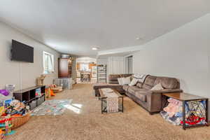 Spacious lower-level living area featuring neutral carpeting, recessed lighting, and white walls