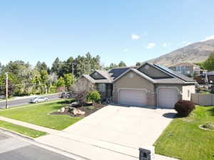 Ranch-style residence featuring a stucco and stone facade, a two-car garage, and a concrete driveway