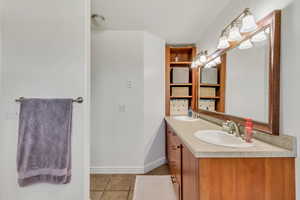 Double vanity with integrated sinks, a wide framed mirror, and warm wood-finish cabinetry