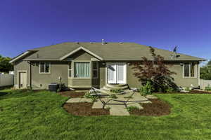 Rear exterior featuring stucco siding, a bay window, and a white double door