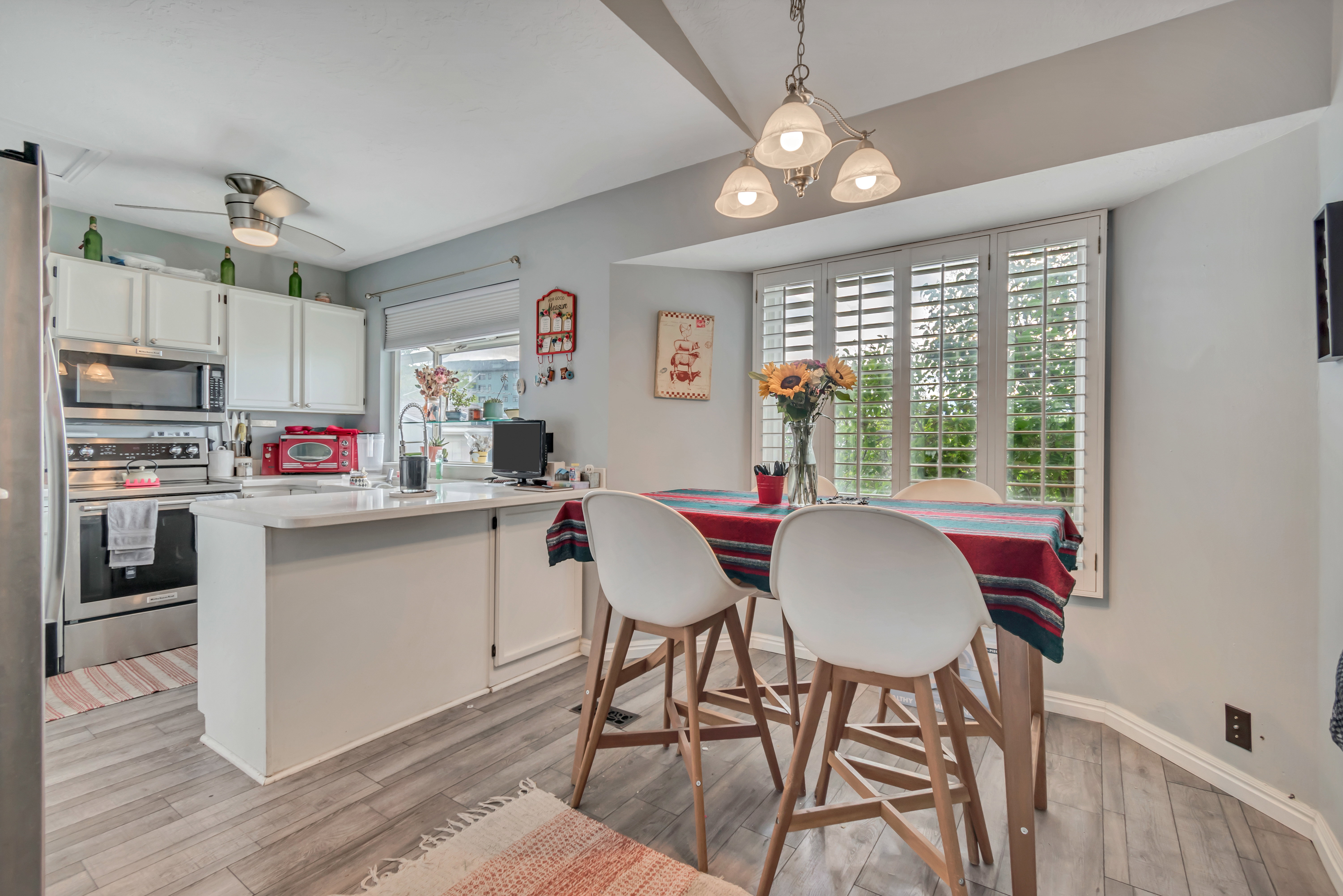 Kitchen with wood-finish flooring and white cabinetry