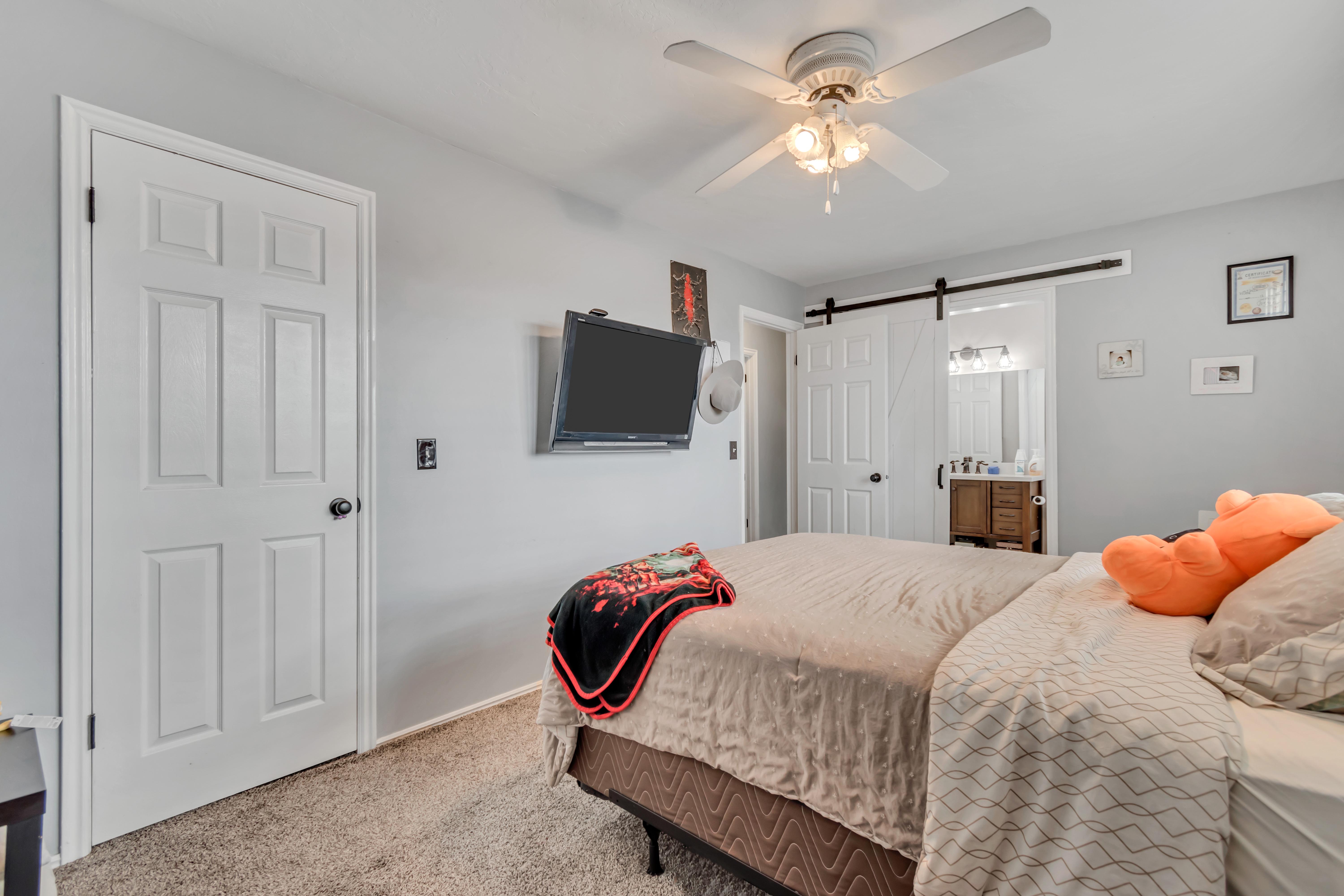 Carpeted room with a ceiling fan light fixture