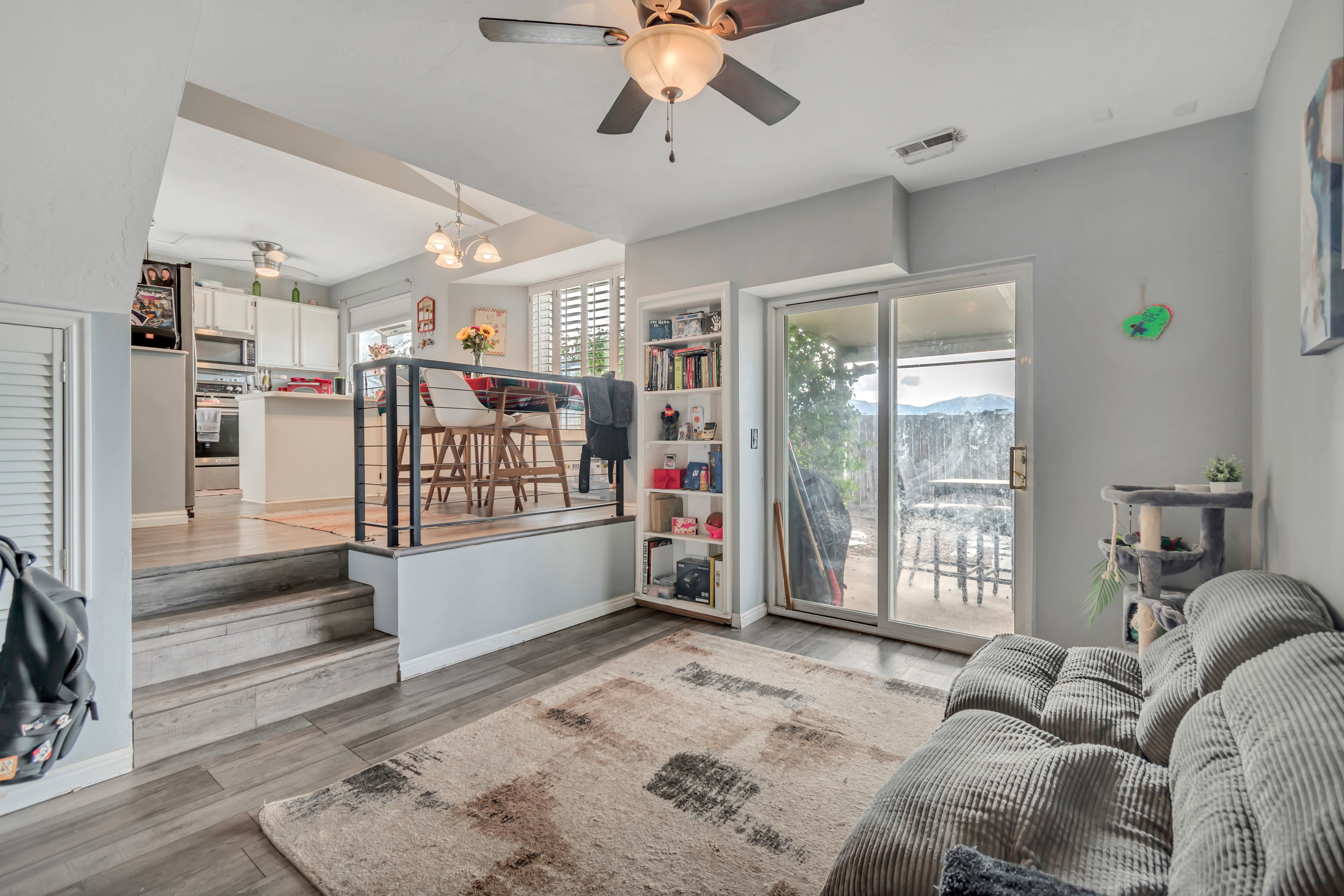 Living area featuring wood-finish flooring, a ceiling fan, and sliding glass doors to the exterior