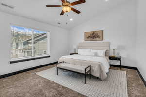 Spacious bedroom featuring a vaulted ceiling with a ceiling fan, plush carpeting, a large window with horizontal blinds, and recessed lighting
