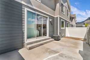 Private concrete patio with a white vinyl fence and mountain backdrop