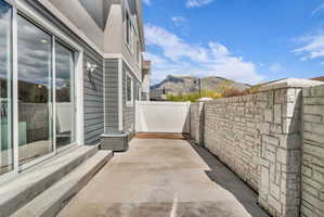 Private patio featuring concrete flooring and a stone-style privacy wall
