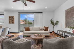 Living area featuring wood-finish flooring and a ceiling fan with integrated lighting