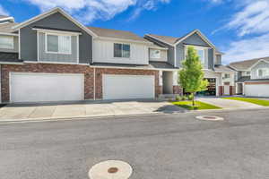Contemporary townhome featuring a mix of brick and horizontal siding, multiple two-car garages, and concrete driveways