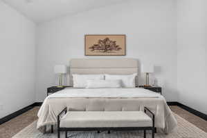 Vaulted ceiling over a neutral-toned room featuring light-colored walls and dark baseboards