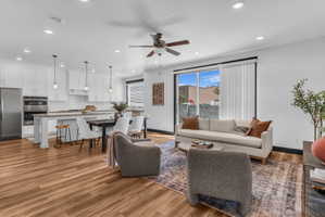 Open-concept living area featuring wood-finish flooring, recessed lighting, and a ceiling fan
