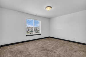 Carpeted interior space with a window featuring horizontal blinds