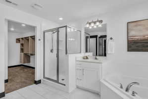 Bathroom featuring white tile flooring and a built-in corner tub with chrome fixtures