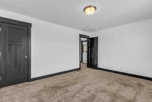 Room featuring light-colored walls, dark trim, and neutral-toned carpeting