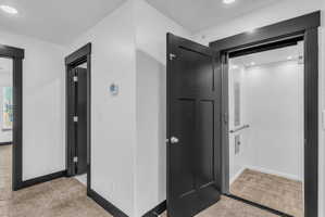 Integrated residential elevator featuring a grab bar and recessed lighting