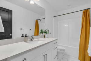 Modern bathroom featuring a white vanity with an integrated sink, a light-toned countertop, and silver-tone hardware