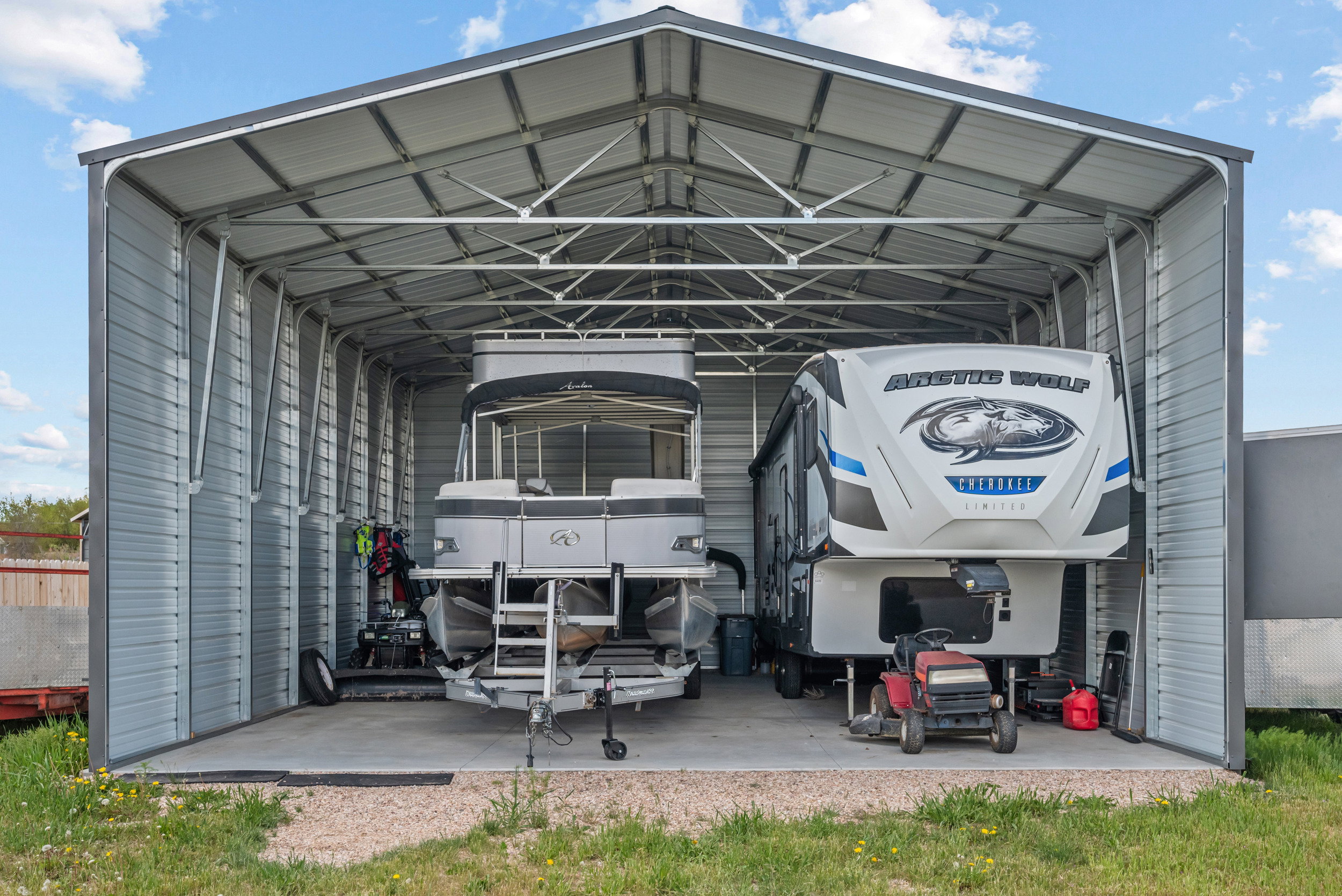 Spacious metal carport structure with a durable concrete pad, offering ample covered storage