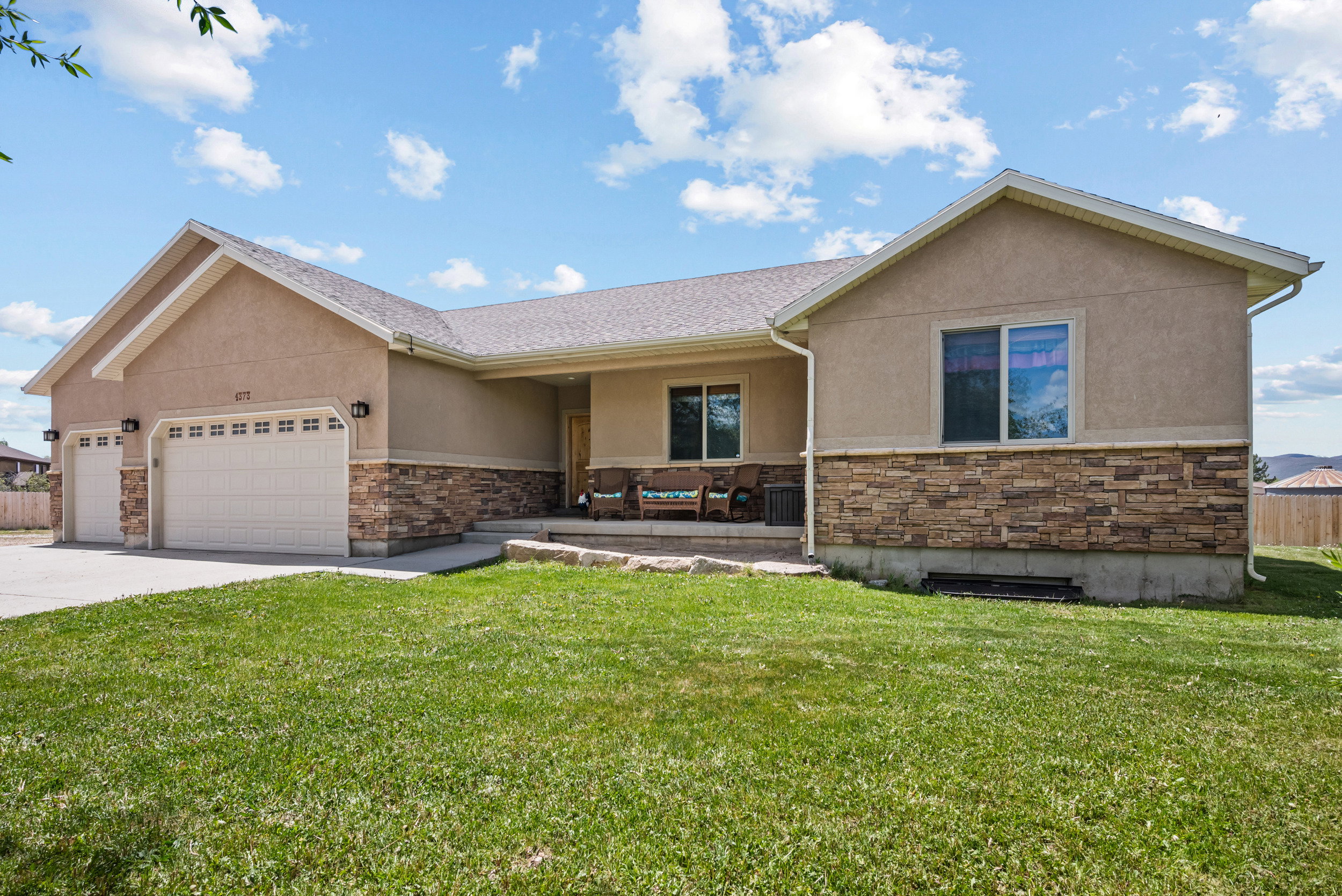 Contemporary ranch-style exterior featuring stucco and stone veneer accents
