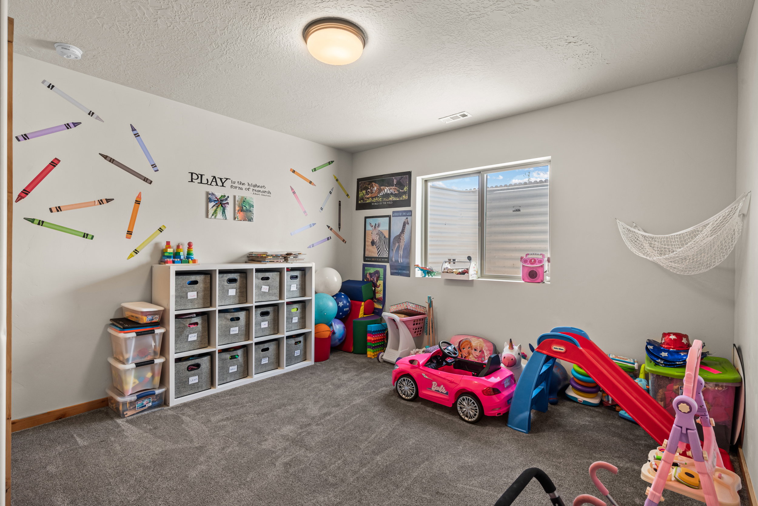 Spacious interior room with light gray carpeting and white walls