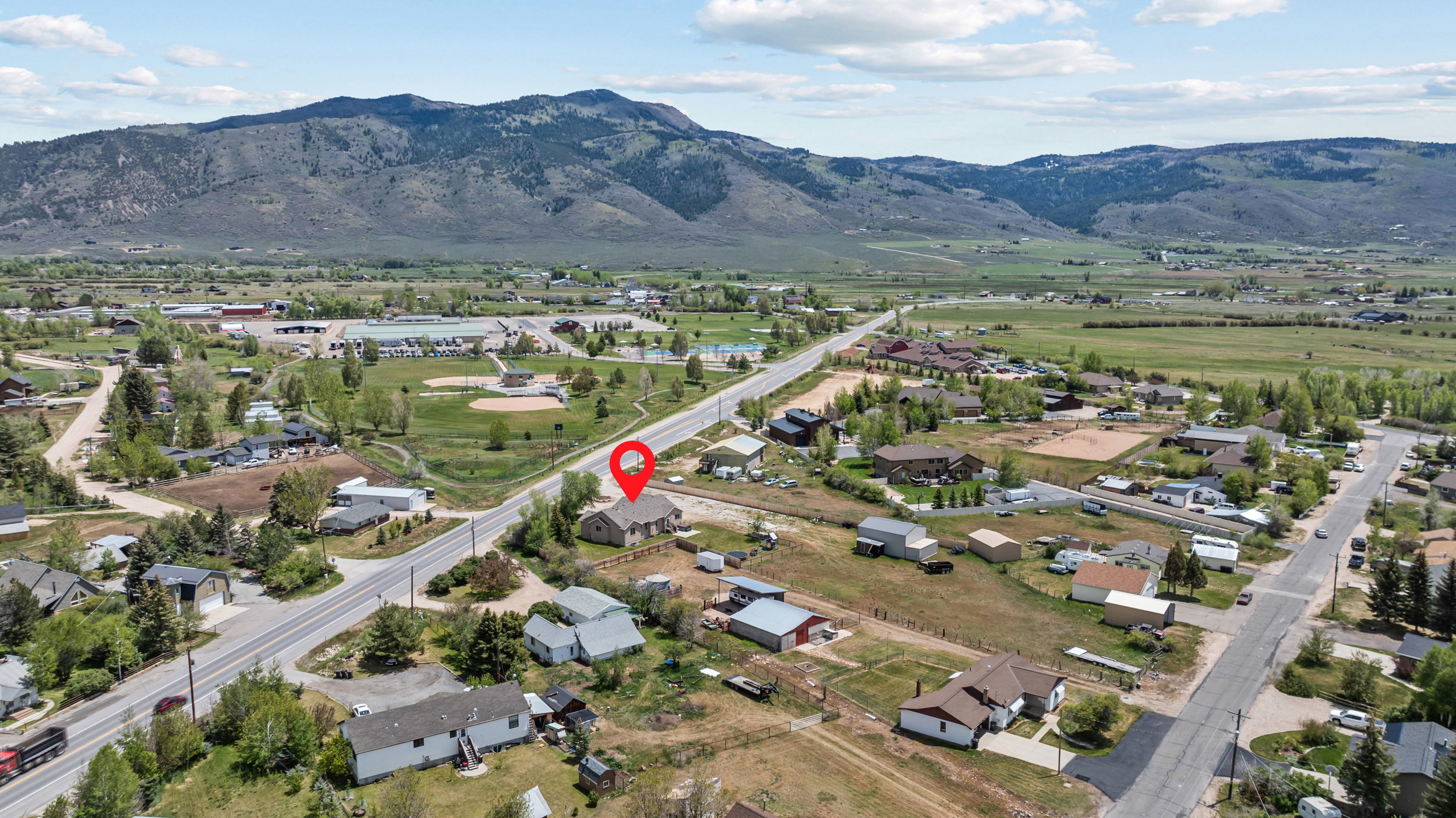 Expansive rural landscape featuring distant mountains and a valley with scattered residential properties