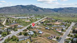 Expansive rural landscape featuring distant mountains and a valley with scattered residential properties