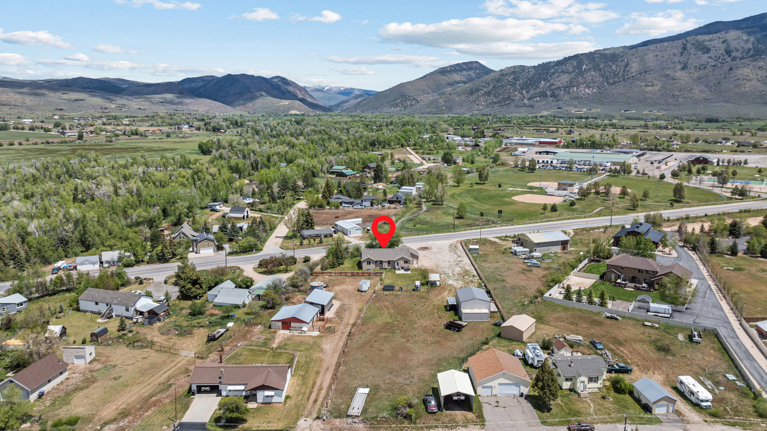 Expansive property featuring a single-story residence and detached garage, set against a backdrop of distant mountains