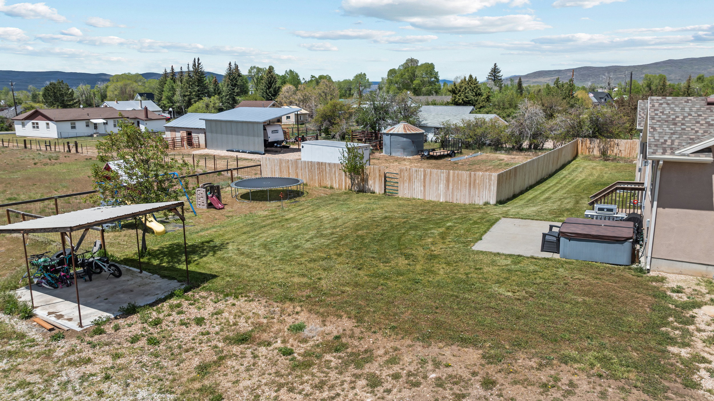 Expansive backyard featuring a manicured lawn, a concrete patio, and a privacy fence