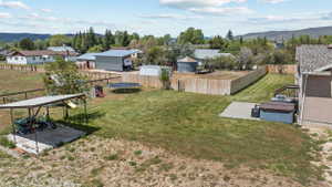 Expansive backyard featuring a manicured lawn, a concrete patio, and a privacy fence