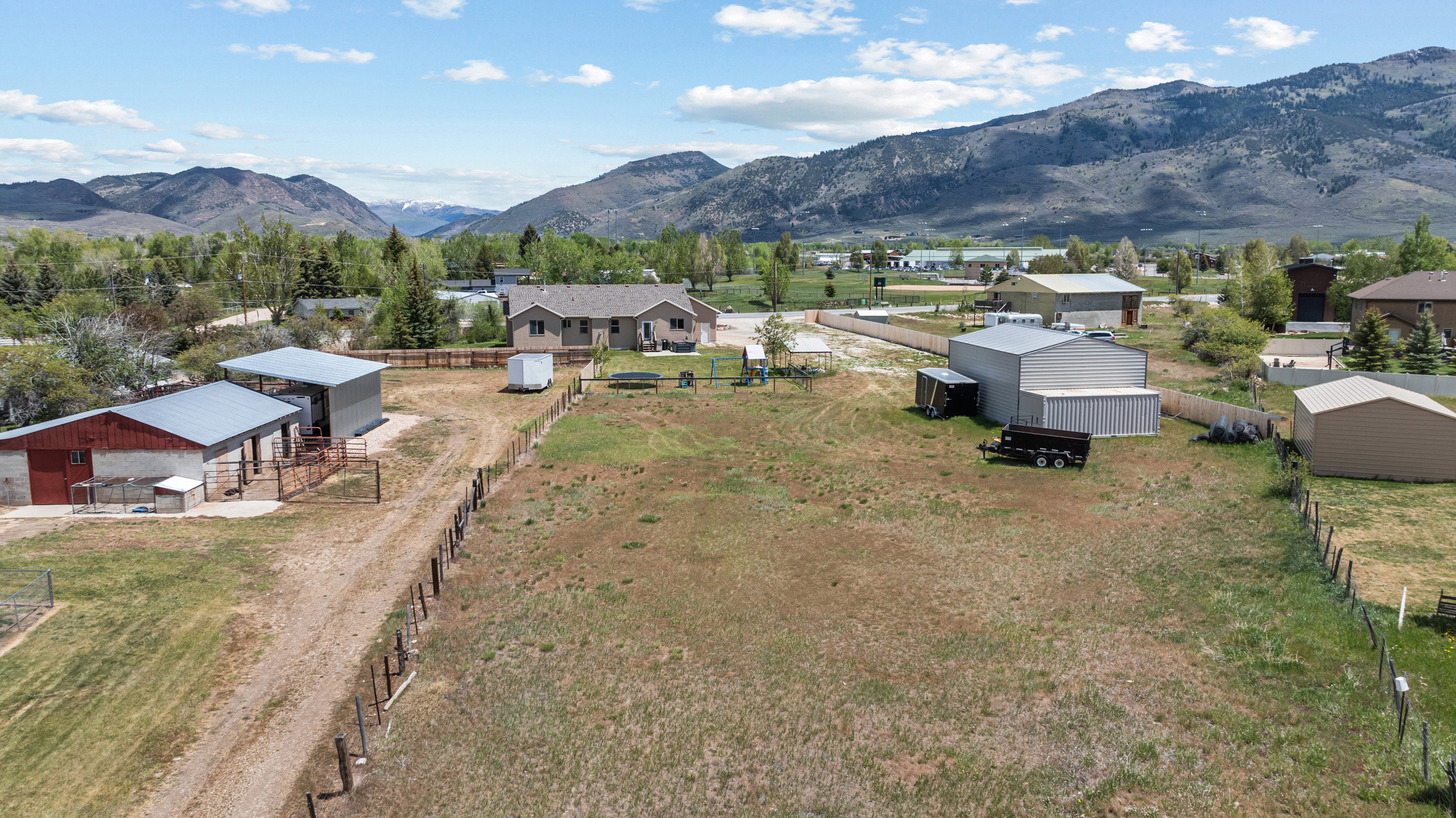 Expansive property featuring a main residence, multiple outbuildings, and mountain scenery
