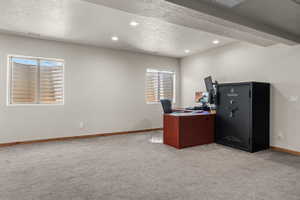 Spacious room featuring light gray carpeting, neutral wall finishes, two egress windows with blinds, wood-finish baseboards, and recessed ceiling lighting